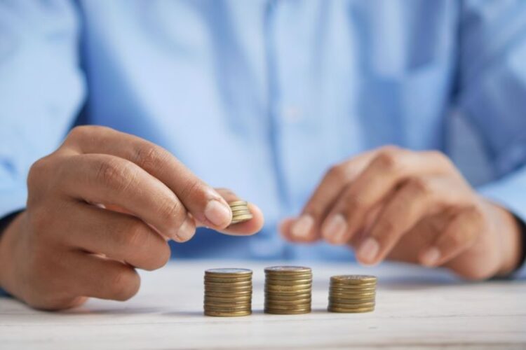 Investment Commodities - a person stacking coins on top of a table