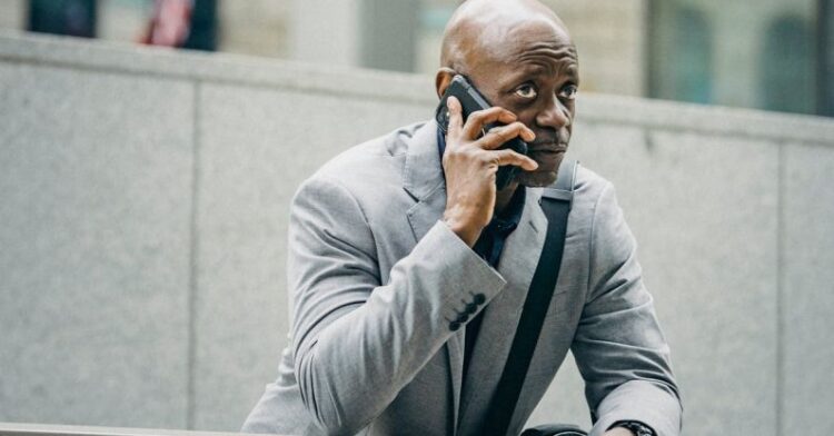 Lean Management - Thoughtful black entrepreneur speaking on cellphone and looking away