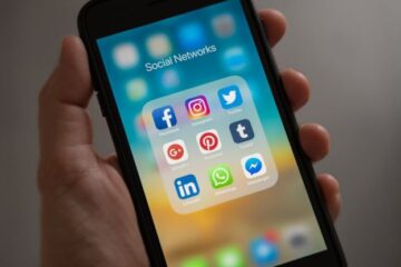 Social Media Marketing - Person Holding Iphone Showing Social Networks Folder