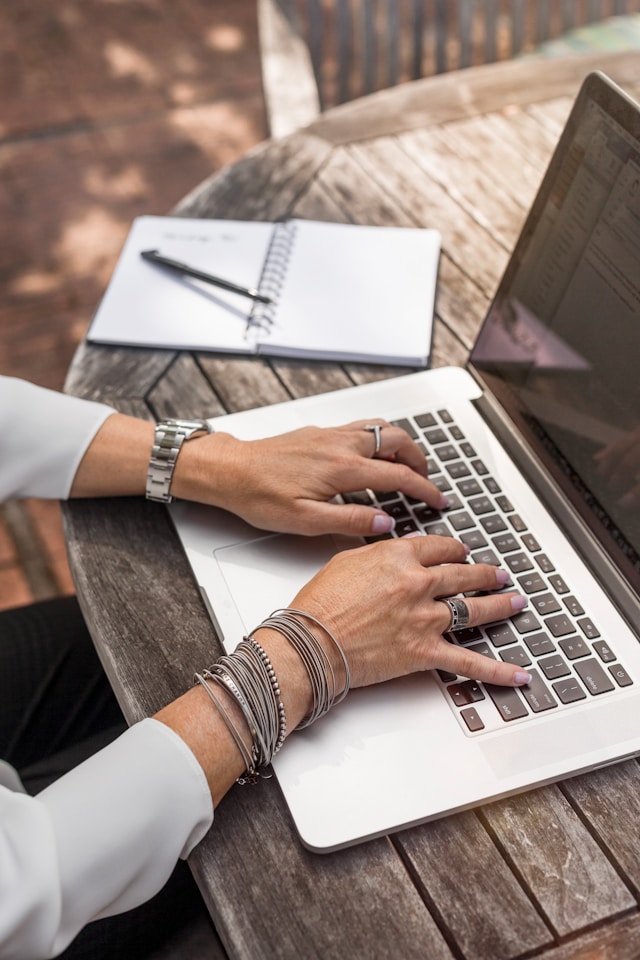 person-typing-on-macbook-pro-on-brown-wooden-table