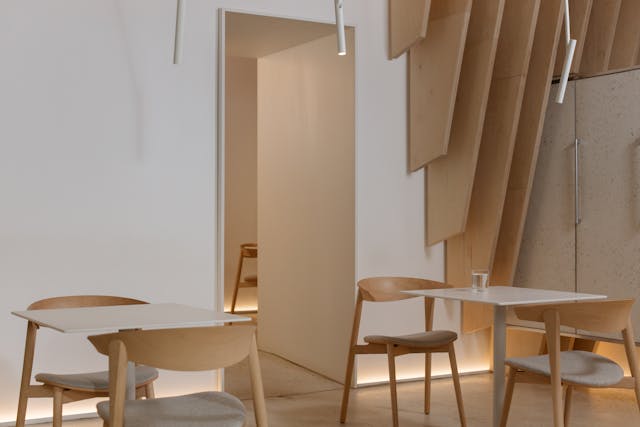 photo-of-a-room-with-white-tables-and-wooden-chairs